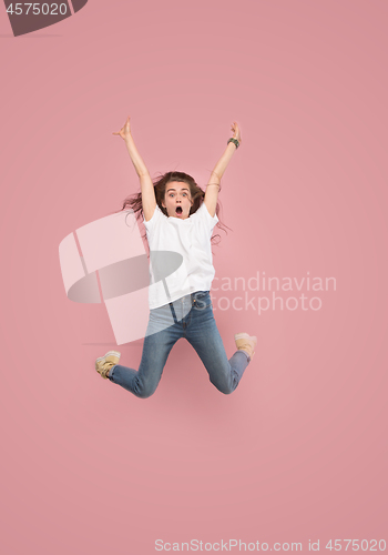 Image of Freedom in moving. Pretty young woman jumping against pink background