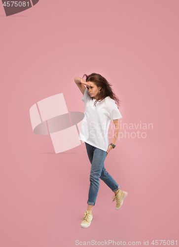 Image of Freedom in moving. Pretty young woman jumping against pink background