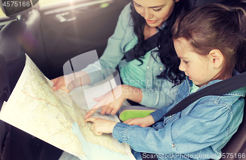 Image of happy family with travel map driving in car