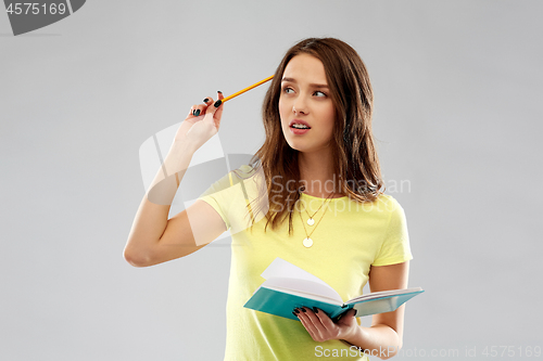 Image of teenage student girl with diary or notebook thinks