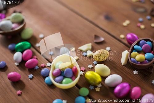 Image of chocolate eggs and candy drops on wooden table