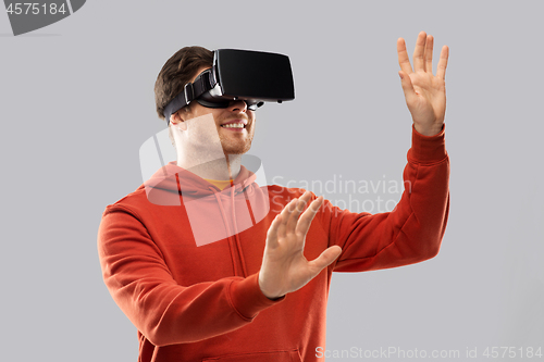 Image of happy man in virtual reality headset or vr glasses