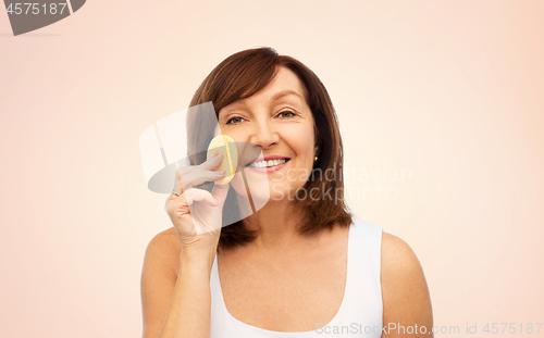 Image of woman cleaning face with exfoliating sponge