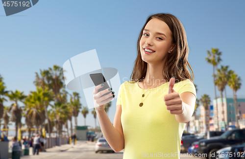 Image of teenage girl with smartphone showing thumbs up