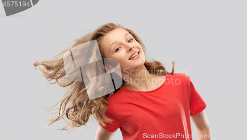 Image of smiling teenage girl in red with long wavy hair