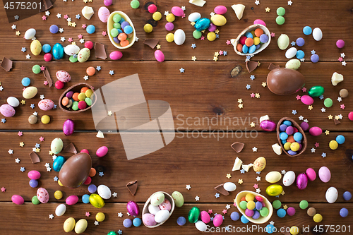 Image of chocolate eggs and candy drops on wooden table