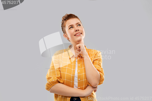 Image of red haired teenage girl looking up and dreaming