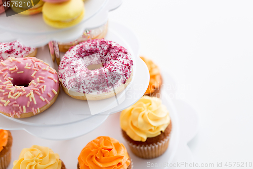 Image of close up of glazed donuts and cupcakes on stand