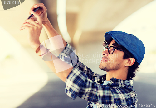 Image of hipster man taking selfie on smartphone