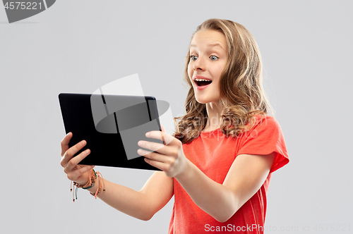 Image of amazed teenage girl with tablet computer