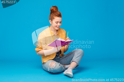 Image of happy teenage student girl with diary or notebook