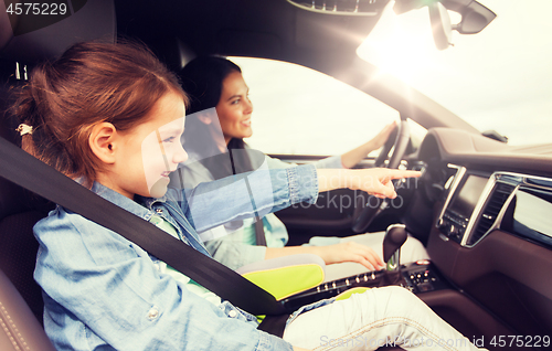 Image of happy woman with little child driving in car