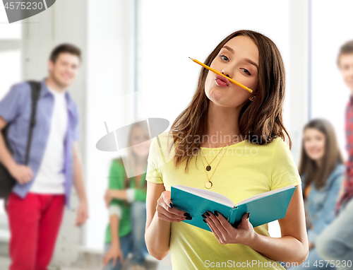 Image of teenage student girl with notebook and pencil