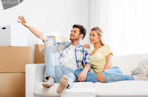 Image of happy couple with cardboard boxes at new home