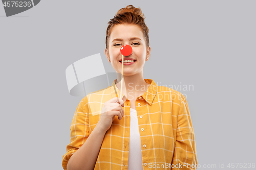 Image of smiling red haired teenage girl with clown nose