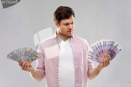 Image of uncertainy man with fans of euro and dollar money