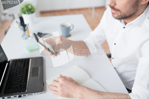 Image of close up of businessman using smartphone at office