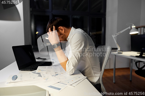 Image of businessman with papers working at night office