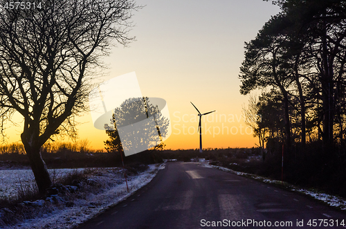 Image of Wind turbine by sunset by a countryroad