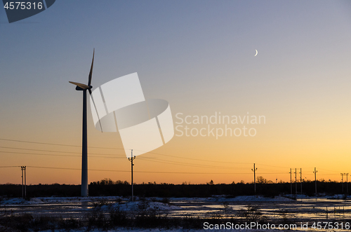 Image of Windmill and power lines by sunset