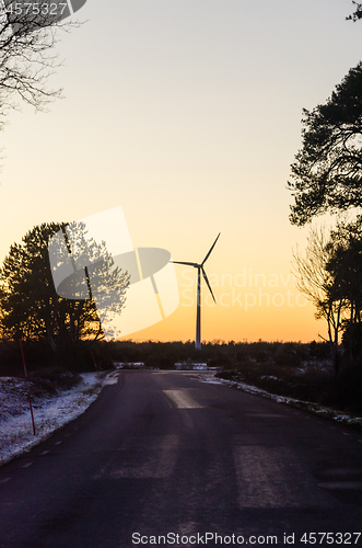 Image of Windmill by sunset by a countryroad