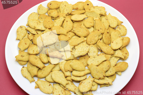 Image of Fish-shaped cookies in a white plate on a crimson background 