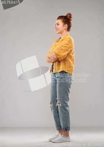 Image of red haired teenage girl in shirt and torn jeans