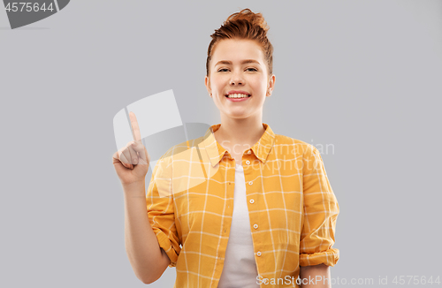 Image of red haired teenage girl showing one finger