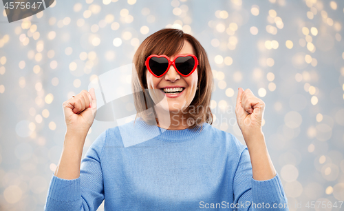 Image of smiling senior woman in heart-shaped sunglasses