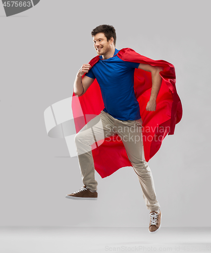 Image of man in red superhero cape jumping in air