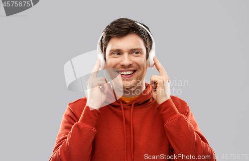 Image of happy young man in headphones and red hoodie