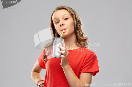 Image of girl drinking soda from can through paper straw