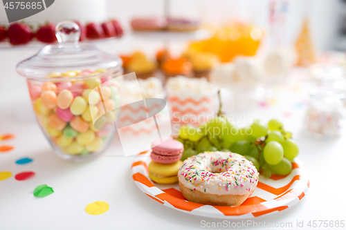 Image of grapes, macarons and donut on party table