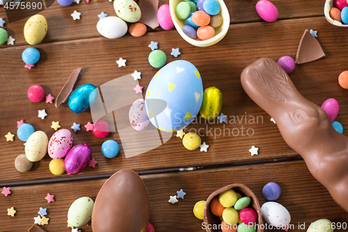 Image of chocolate eggs, easter bunny and candies on wood