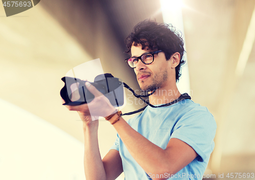 Image of photographer with digital camera shooting in city