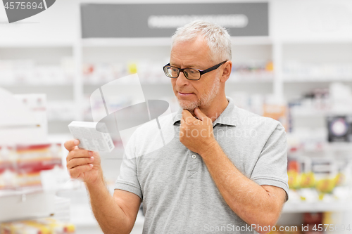 Image of senior male customer with drug at pharmacy