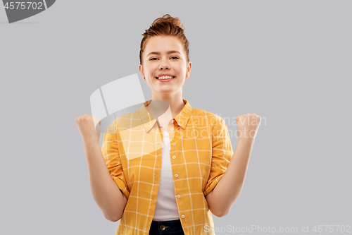 Image of happy red haired teenage girl celebrating success