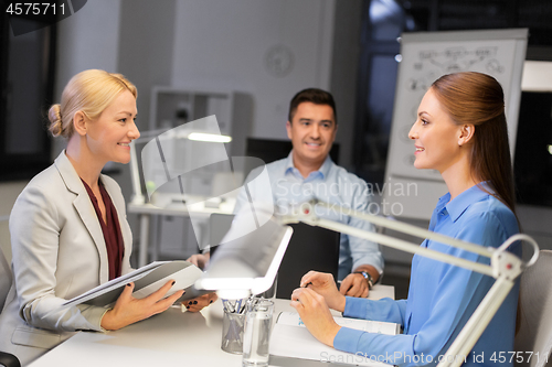 Image of business team with laptop working late at office