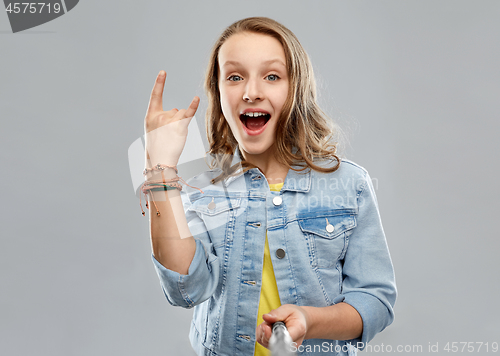 Image of teenage girl taking picture by selfie stick