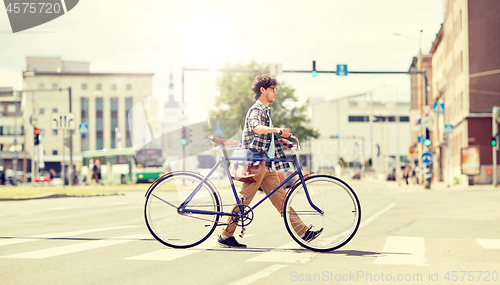 Image of young man with fixed gear bicycle on crosswalk