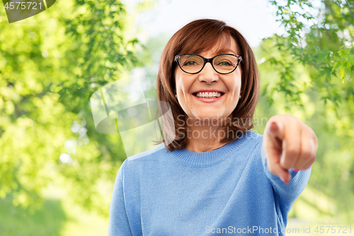 Image of senior woman in glasses pointing finger to you