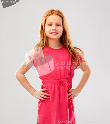 Image of smiling red haired girl posing in pink dress