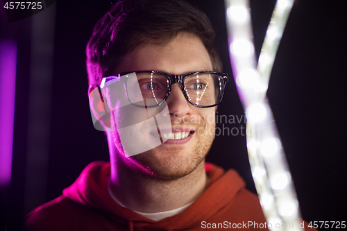 Image of portrait of man in glasses over neon lights