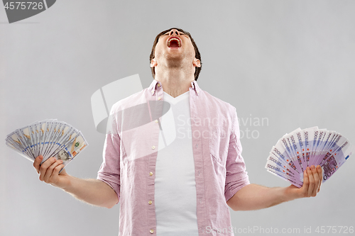 Image of screaming young man with euro and dollar money