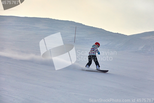 Image of Female snowboarder in sun flare