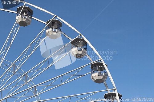 Image of White ferris wheel against blus sunny sky