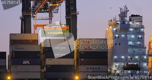 Image of Loading containers on a ship at dawn
