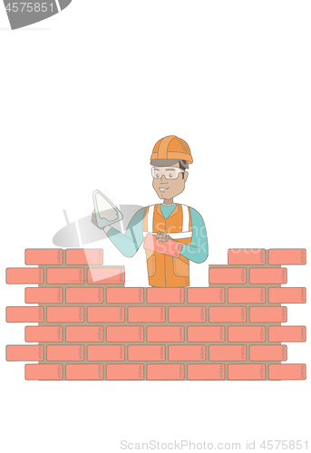 Image of Young bricklayer working with spatula and brick.