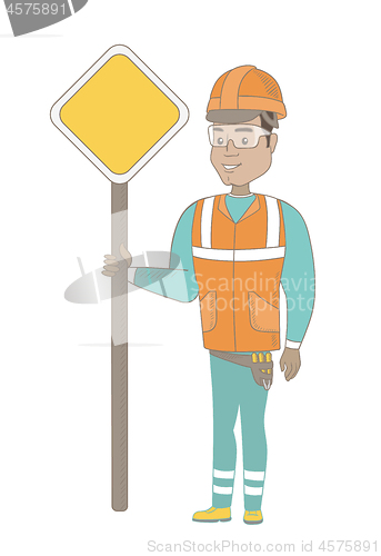 Image of Young hispanic road worker showing road sign.