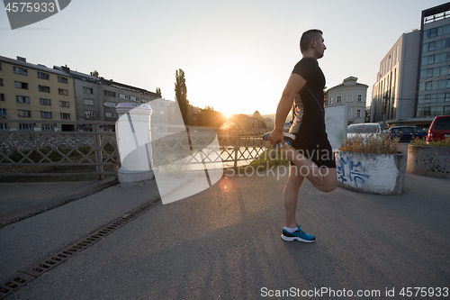 Image of athlete man warming up and stretching